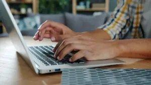 A person typing a web address on a laptop