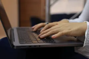 A writer typing an email on a laptop
